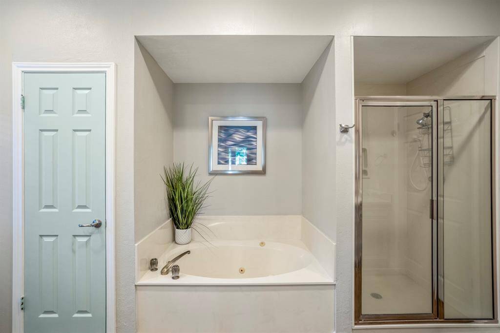 Tucked away to save space is the whirlpool tub, and a glass enclosed shower.