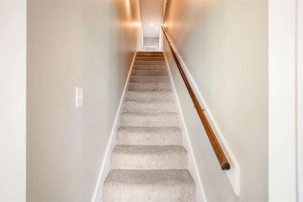 The stairs leading to the second floor living with wood hand rail.