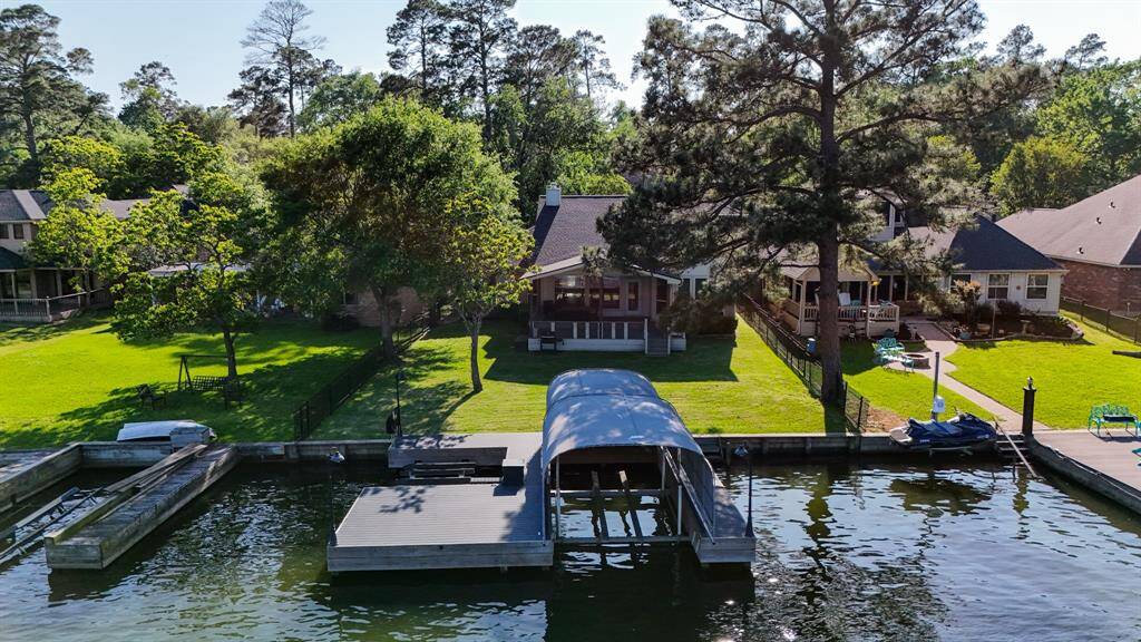 An aerial view of the dock as well as the home and surrounding beautiful properties on Lake Conroe.