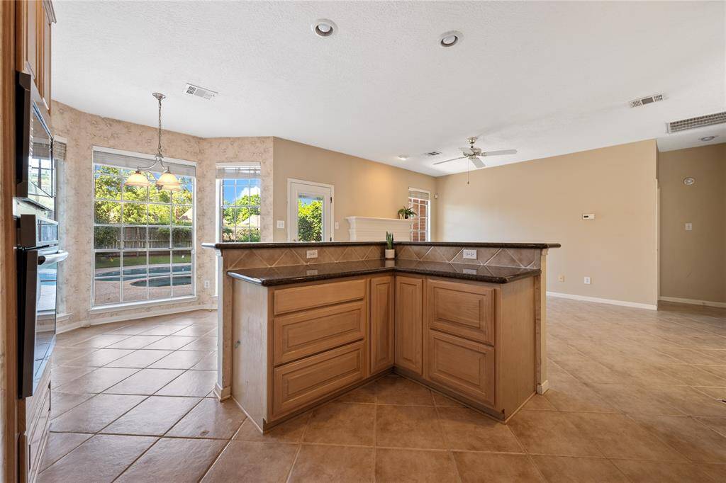Bright, open kitchen and living area with large windows overlooking the backyard.