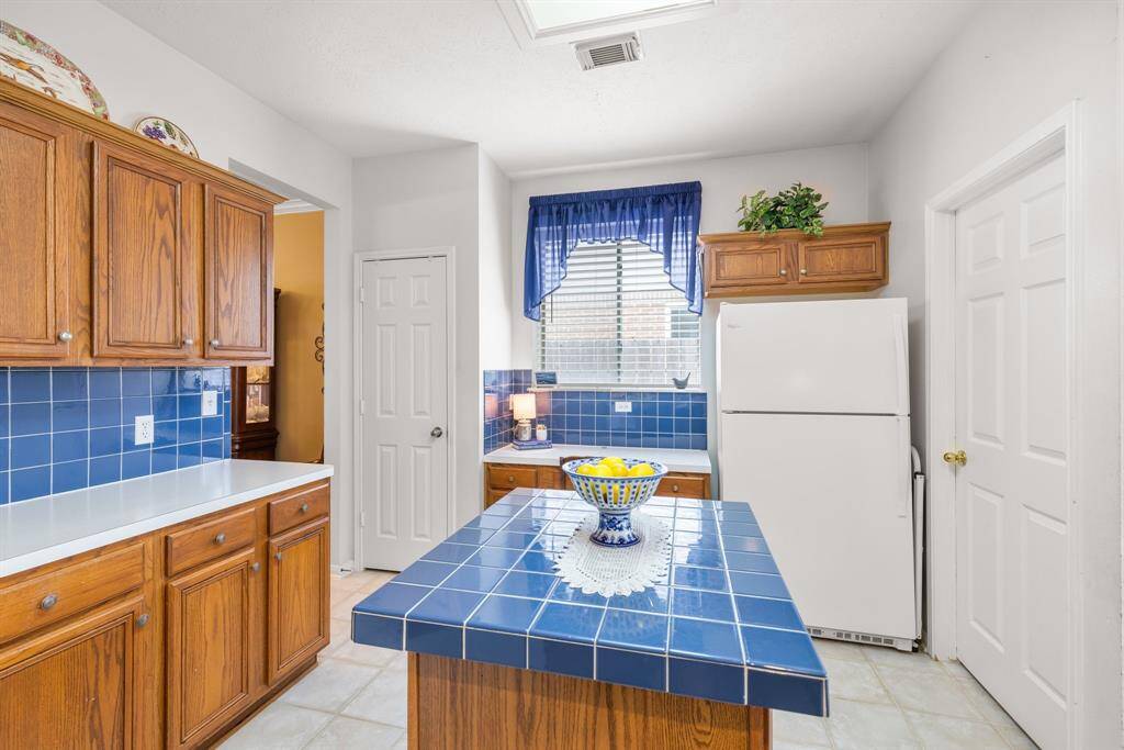 KITCHEN - This view shows the built-in planning desk.  The window over the desk provides lots of natural light to the kitchen area.  Pantry is on the left, and utility room is to the right of the refrigerator.