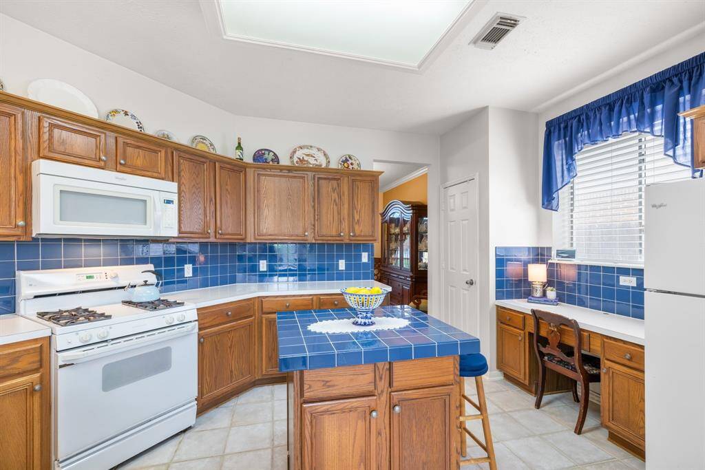 KITCHEN - Island has extra storage space.  Gas range with microwave above.