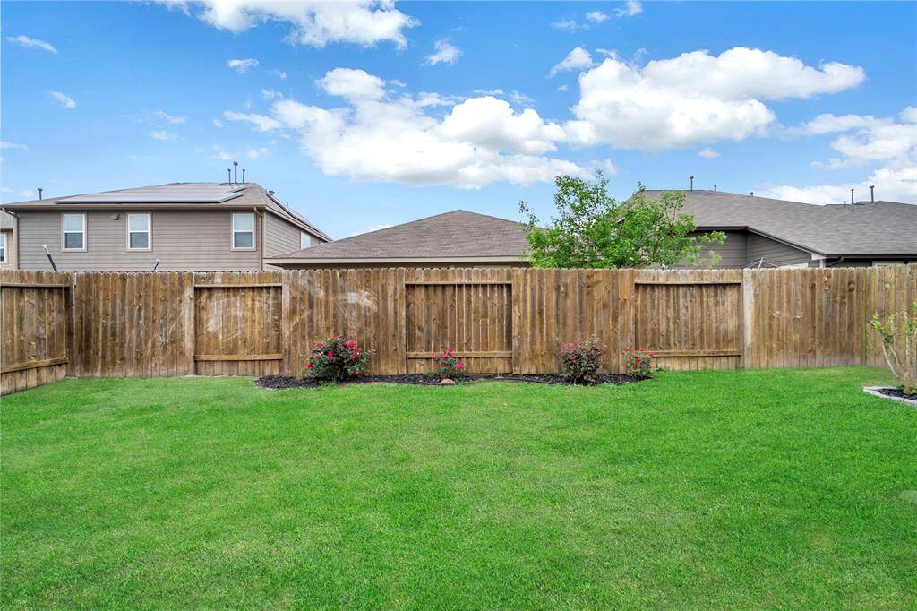 A cozy backyard with a neatly manicured lawn, bordered by a wooden fence for privacy. Perfect for relaxing or entertaining.