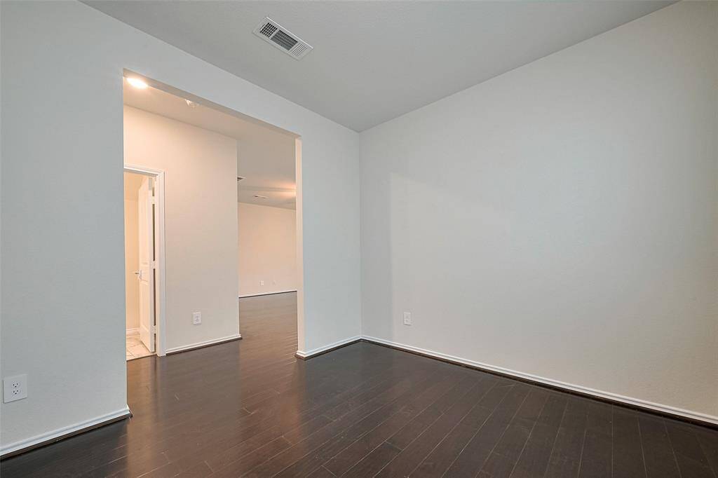 Bathed in natural light from large windows, the formal dining room continues the home’s elegant flooring and offers a generous footprint, easily accessed through a wide, open doorway.