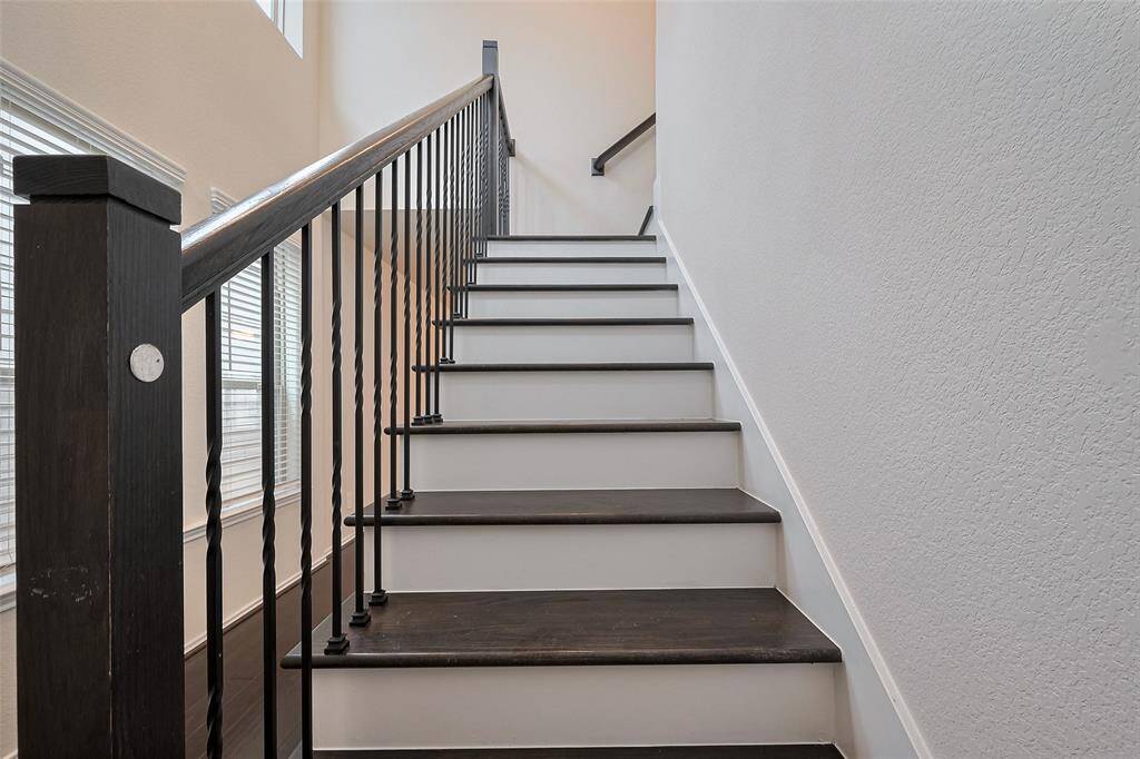 Dark wood steps make a bold contrast against light walls, drawing the eye upward and adding an elegant architectural detail right at the entrance.