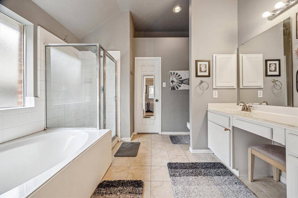 Primary bathroom with double sinks and separate bath and shower.