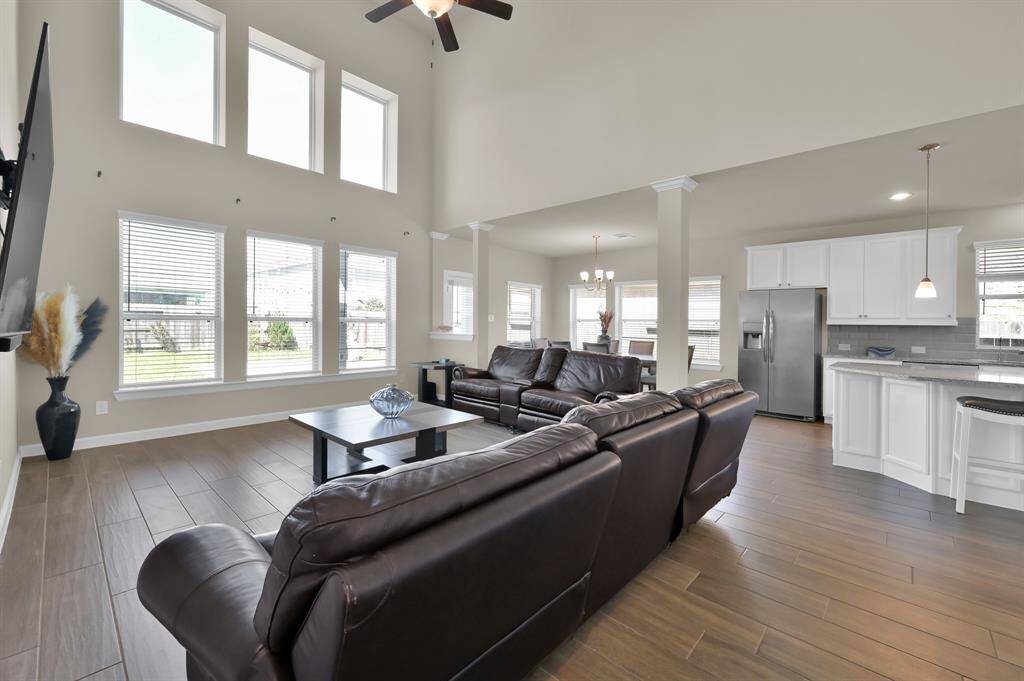 This open floor plan connects the Living Room, Dining, and Kitchen. Floor to ceiling windows provide impressive natural light and show off the dramatic ceiling height.