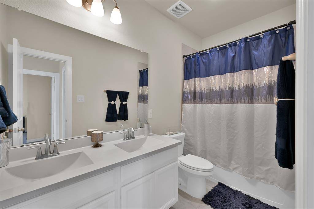 One of the upstairs full baths, which includes dual sinks.