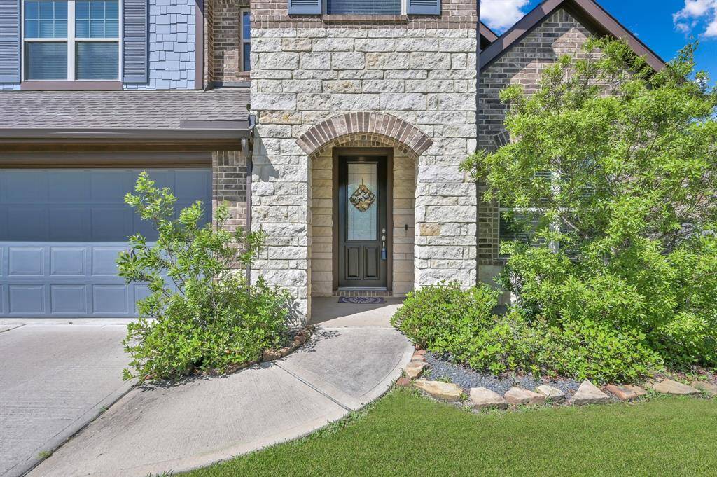 The warm wood front door with rain patterned privacy glass begs for you to come see what's inside.