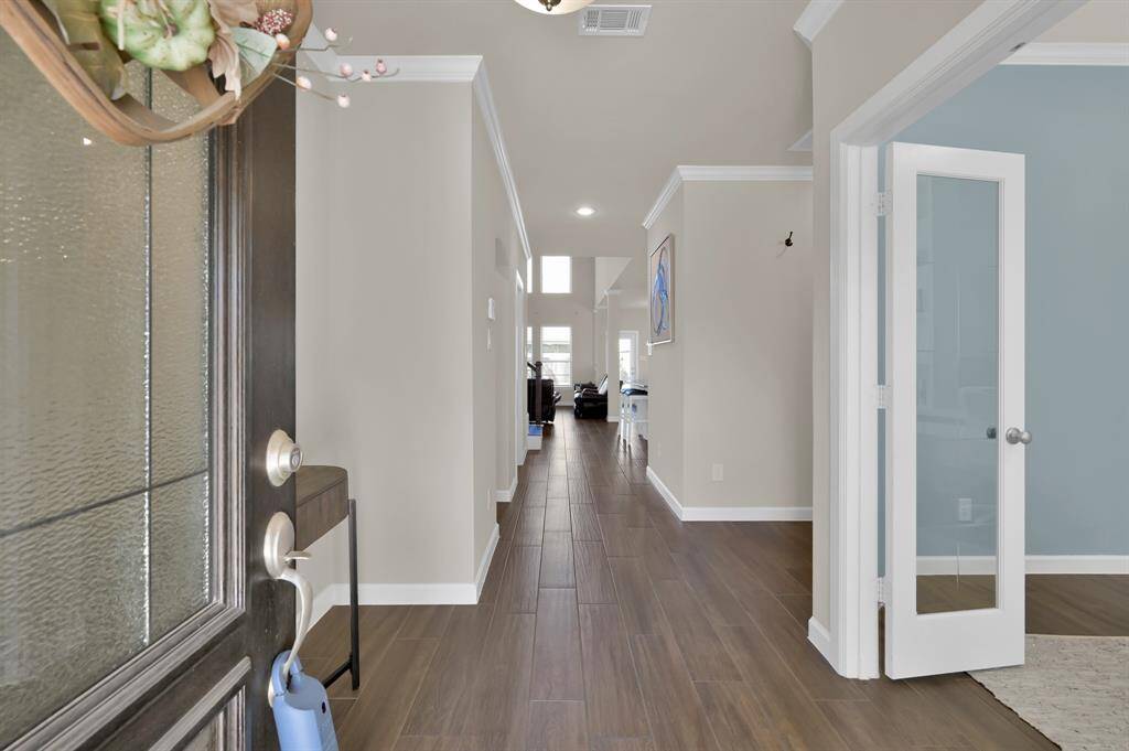 You've arrived... and are immediately greeted with wood-look tile, a neutral color palette, and a view straight back to the heart of the home and an impressive open layout.