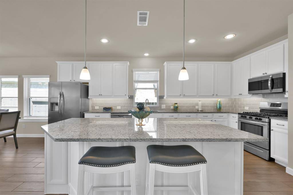 Abundant granite counter top space and an over the sink window make preparing meals for family and guests relaxing and enjoyable.