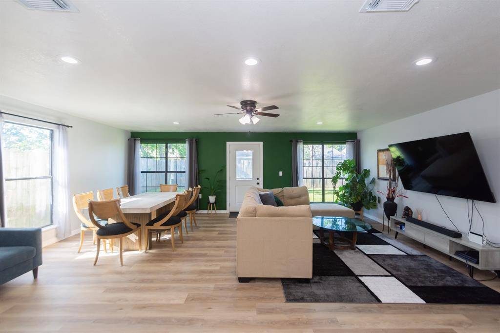 Expansive living and dining area filled with natural light, thanks to large windows that create an open and airy atmosphere.