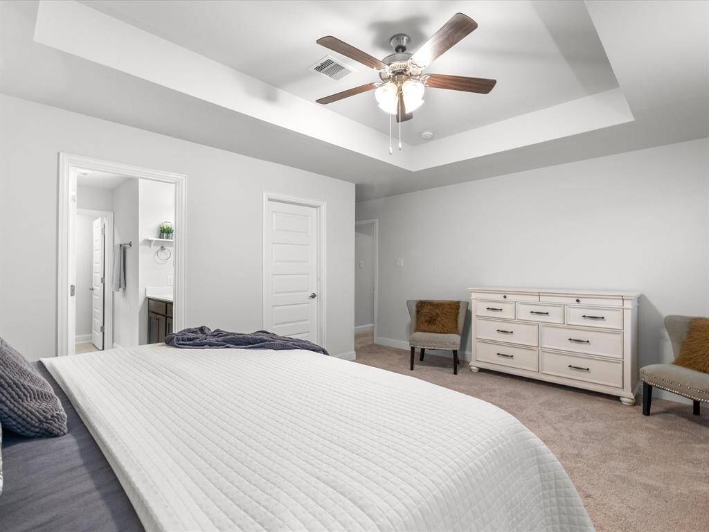 Another view of the primary bedroom, where every room is equipped with a ceiling fan for added comfort.