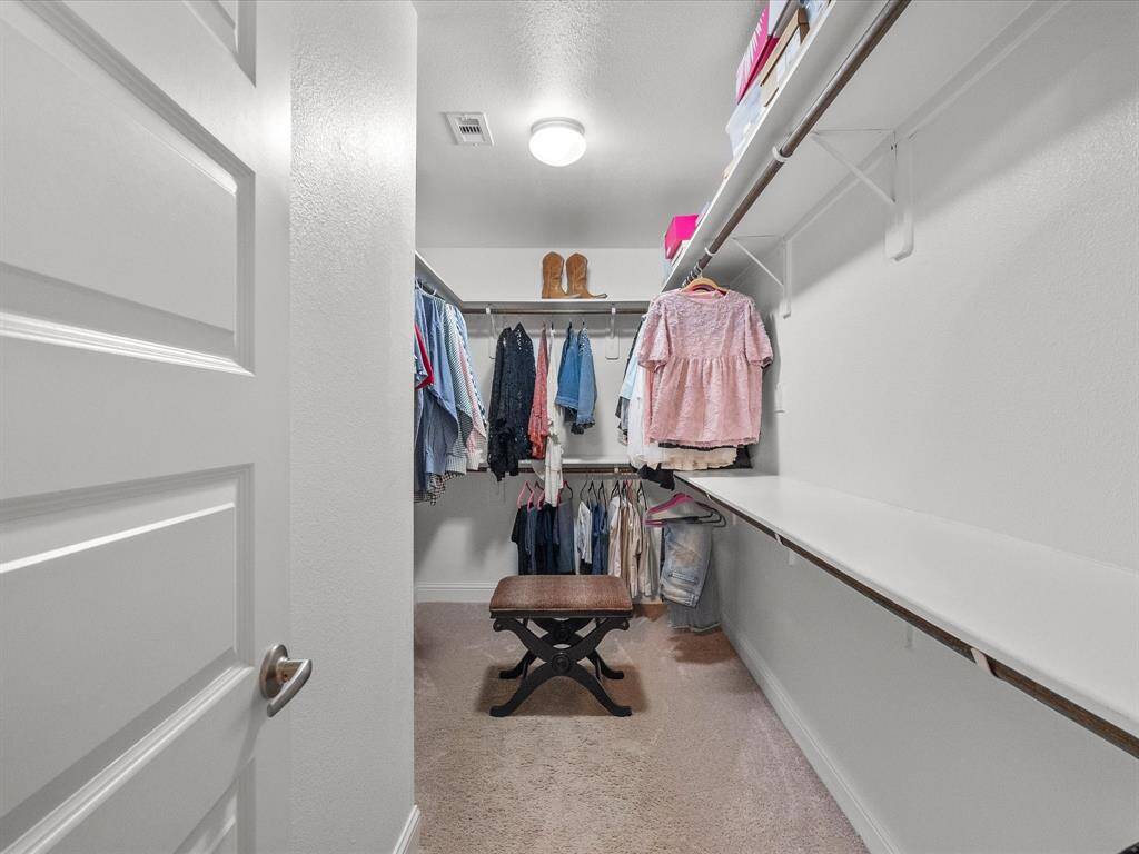 An impressive walk-in closet with plenty of space to accommodate your entire wardrobe.
