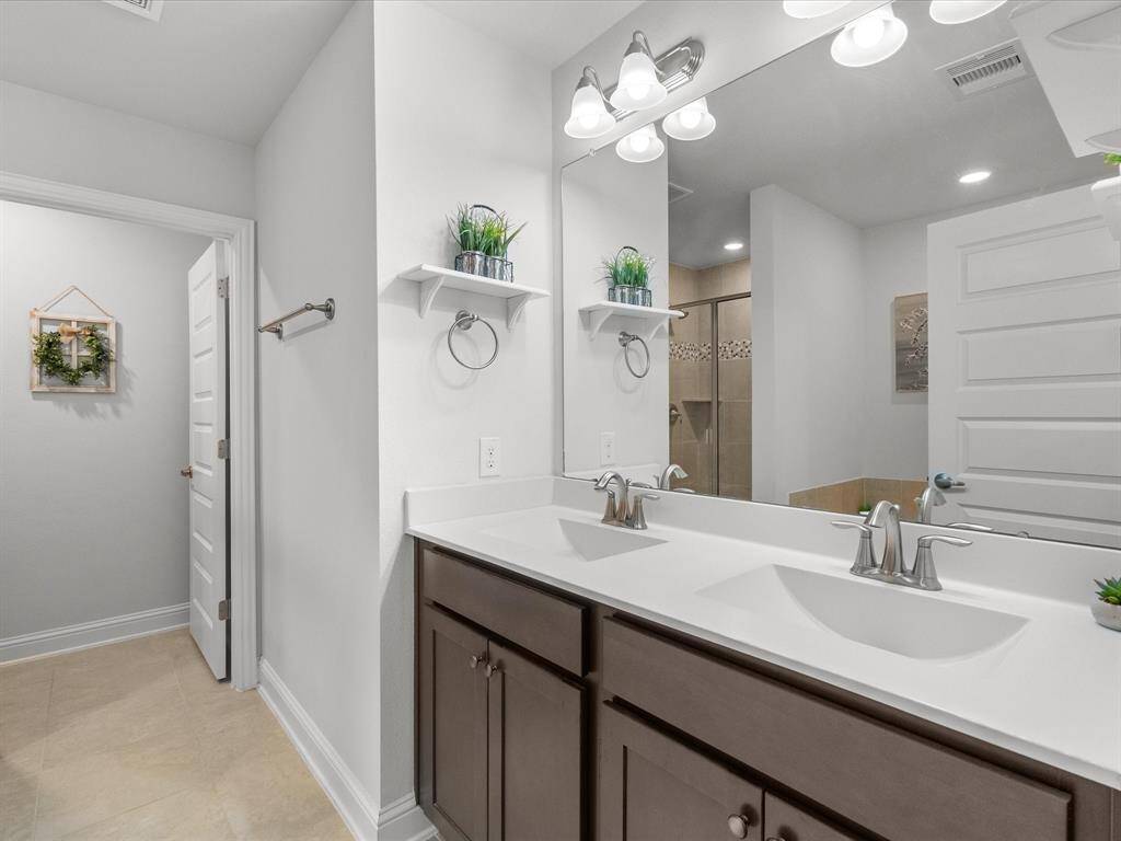 The primary bath boasts a double vanity sink, providing space for daily routines
