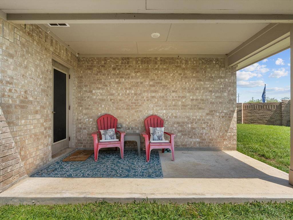 A charming covered patio provides a shaded space for year-round enjoyment.