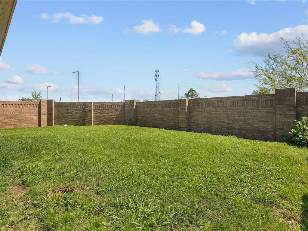 The expansive backyard provides the perfect canvas for your outdoor ideas and projects. Note the back brick wall!