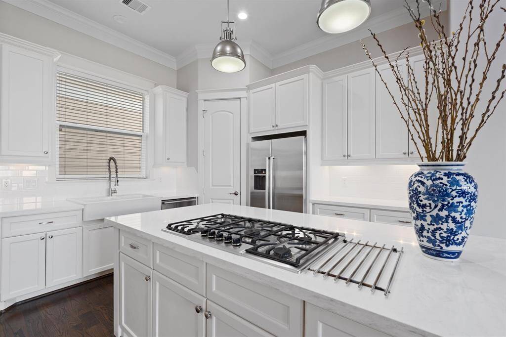 The kitchen features white cabinets,creating a clean and timelessaesthetic.