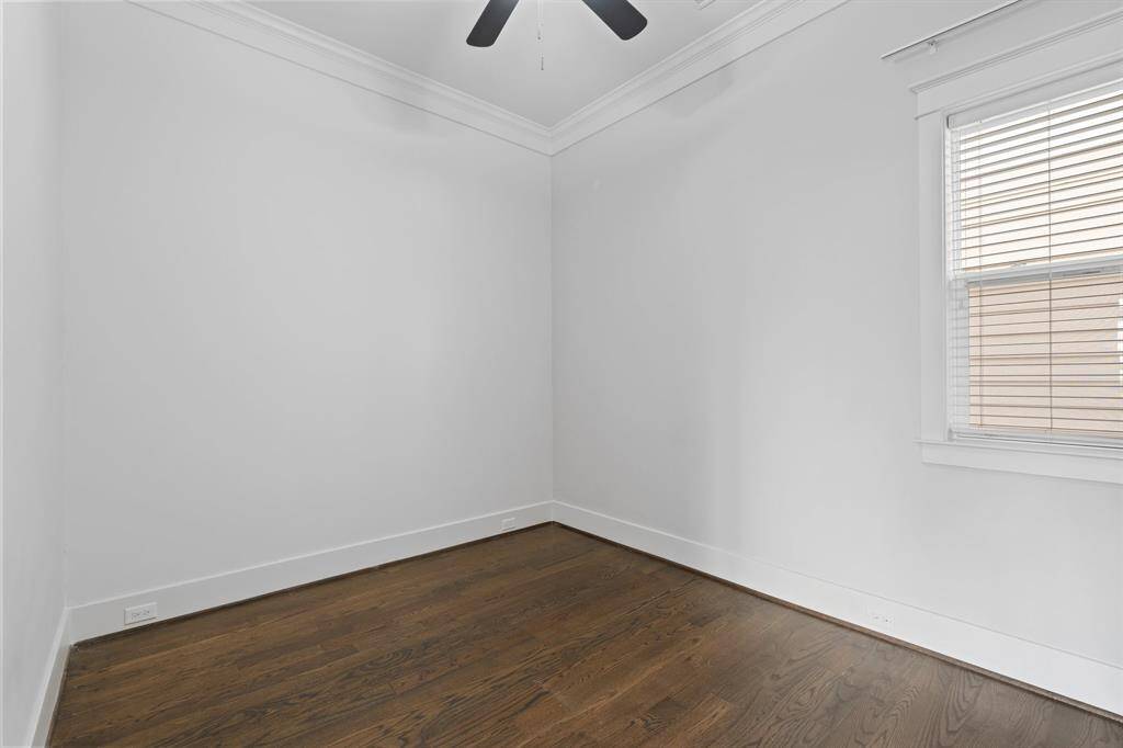 Second floor bedroom features awindow, ceiling fan, and crown molding.