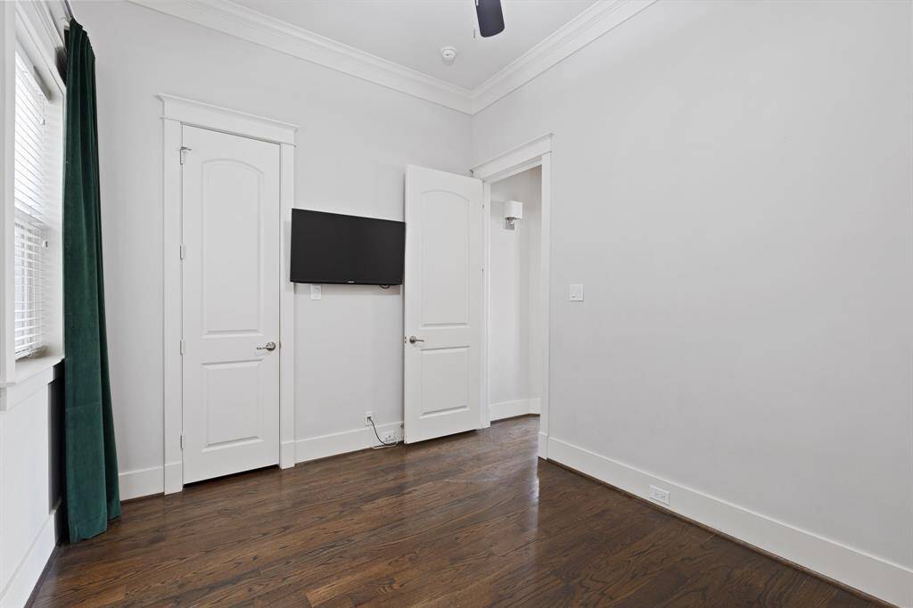 Second floor bedroom features awindow, ceiling fan, and crown molding.