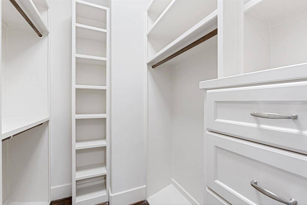 The primary walk-in closet has built-in shelving and storage space.