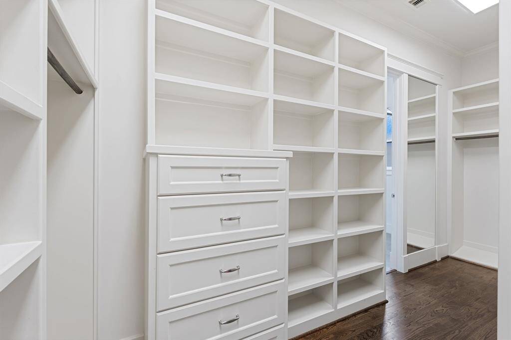The primary walk-in closet has built-in shelving and storage space.