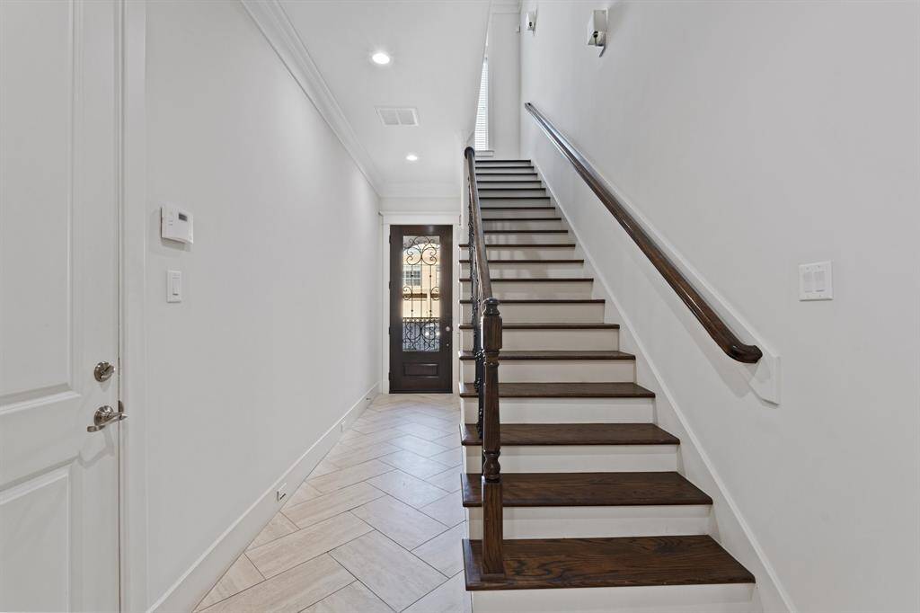 The first floor has tile floors, one bedroom, and the staircase to the second floor.