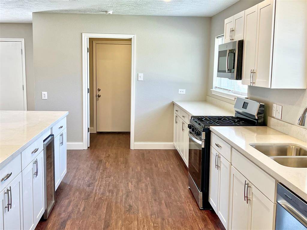 Stainless steel appliances include the gas range, dishwasher and a mini beverage fridge
