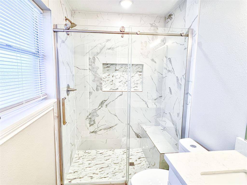Stunning tiled shower with bench seat in the primary bathroom