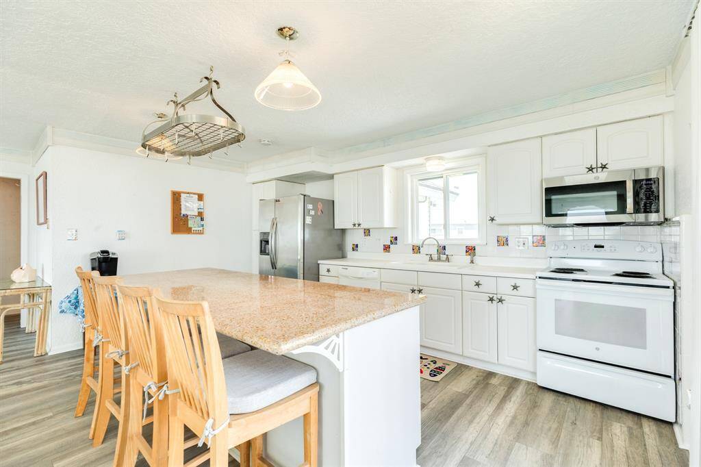 Another view of the kitchen with lots of cabinets and prep space.