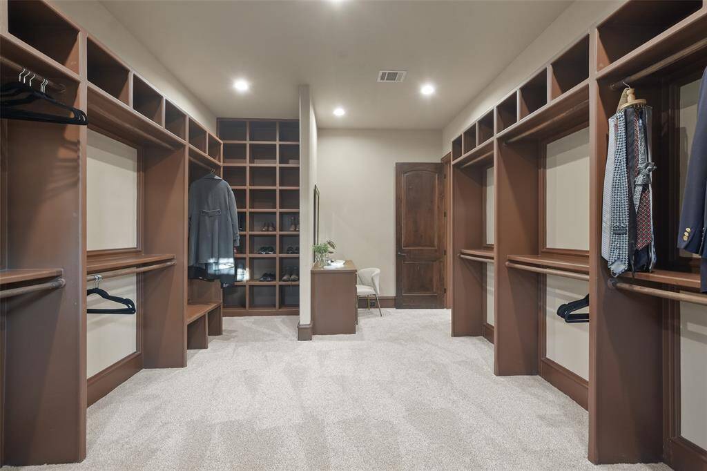 Huge closet with custom closet system and a vanity.