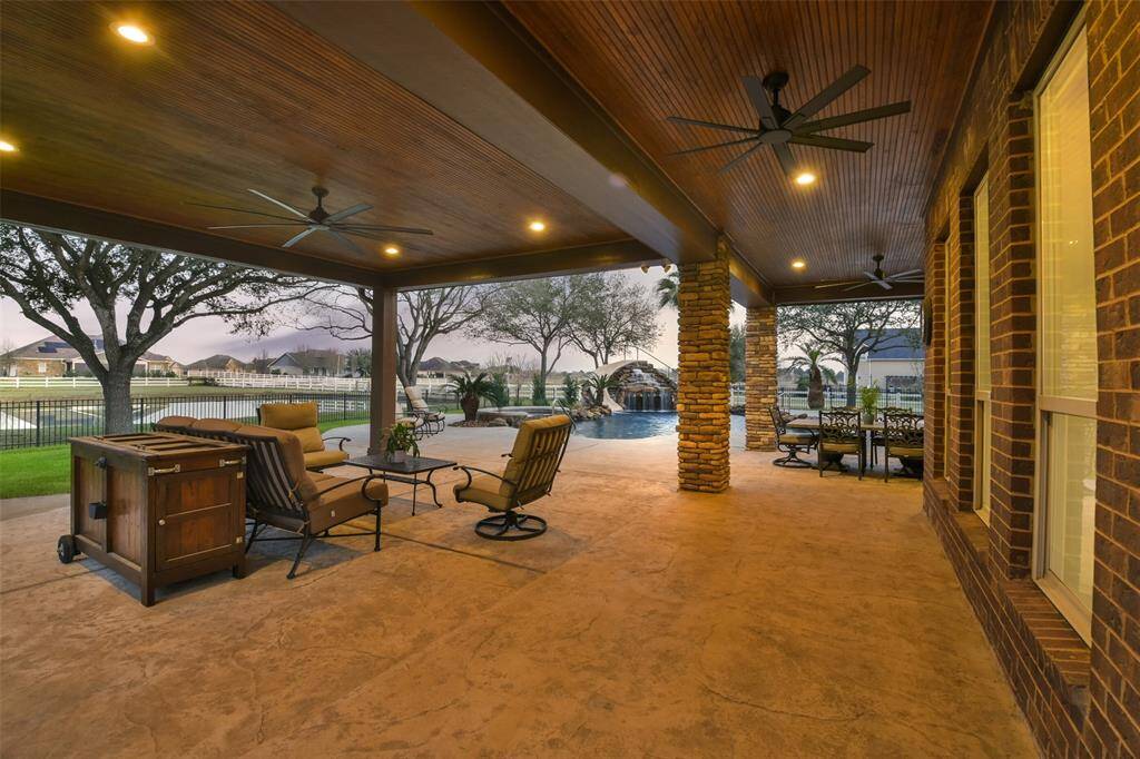 Huge covered patio with recessed lighting and stained wood ceiling.