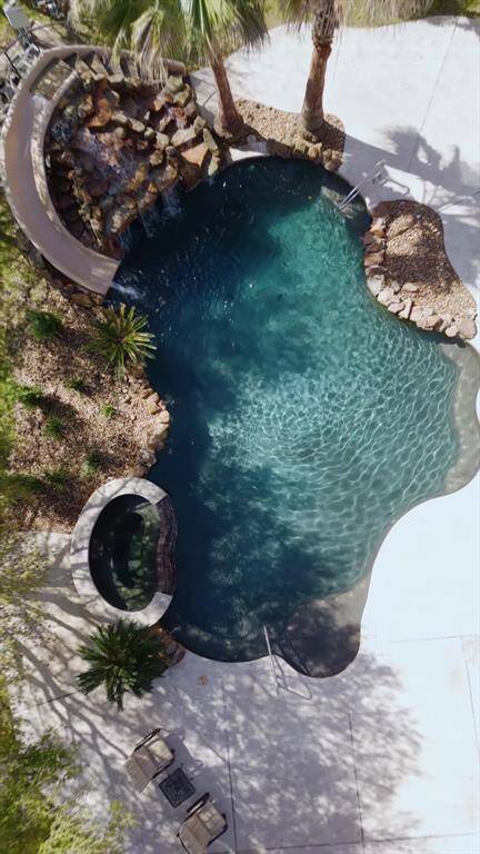 The pool features a hot tub, and a rock waterfall with a slide and cave.