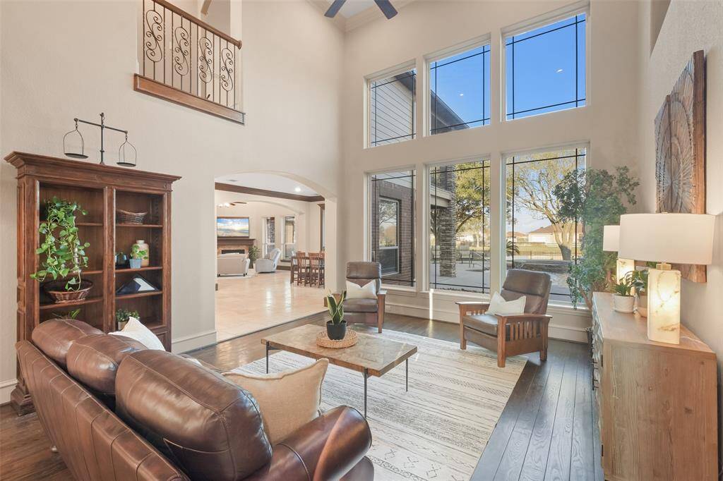 The formal living room features soaring ceilings, a wall of windows that provide abundant natural light & backyard views.