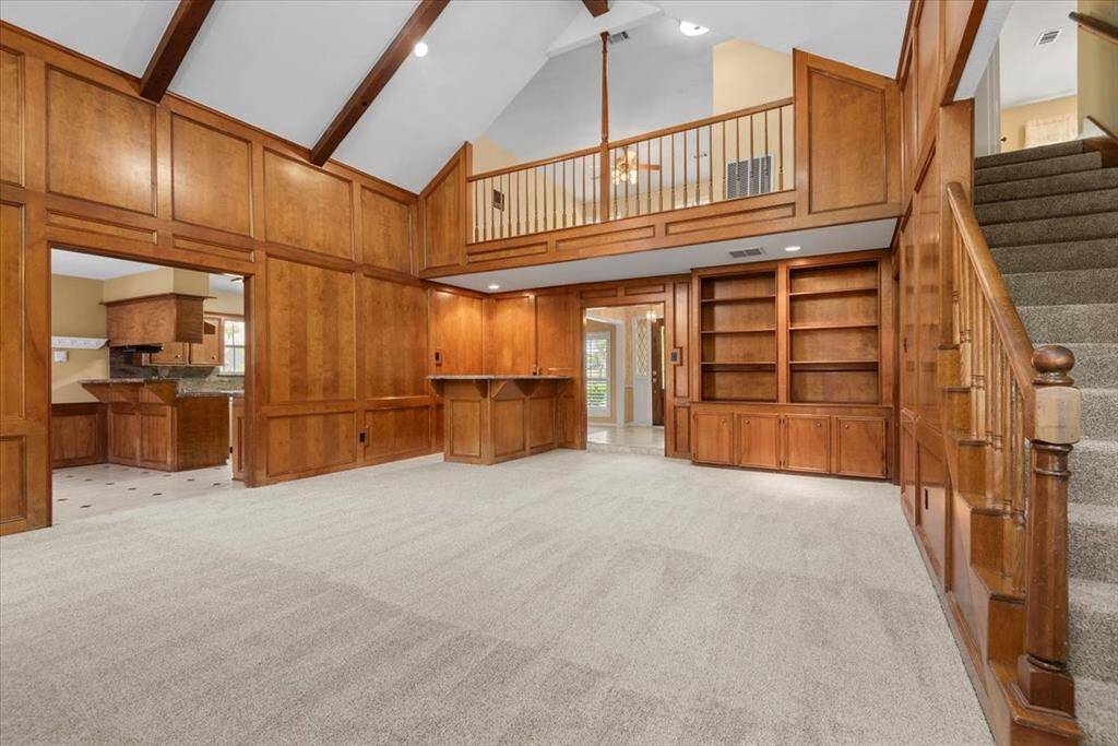 A custom bult in, beamed ceilings and bar area add architectural interest to this room.