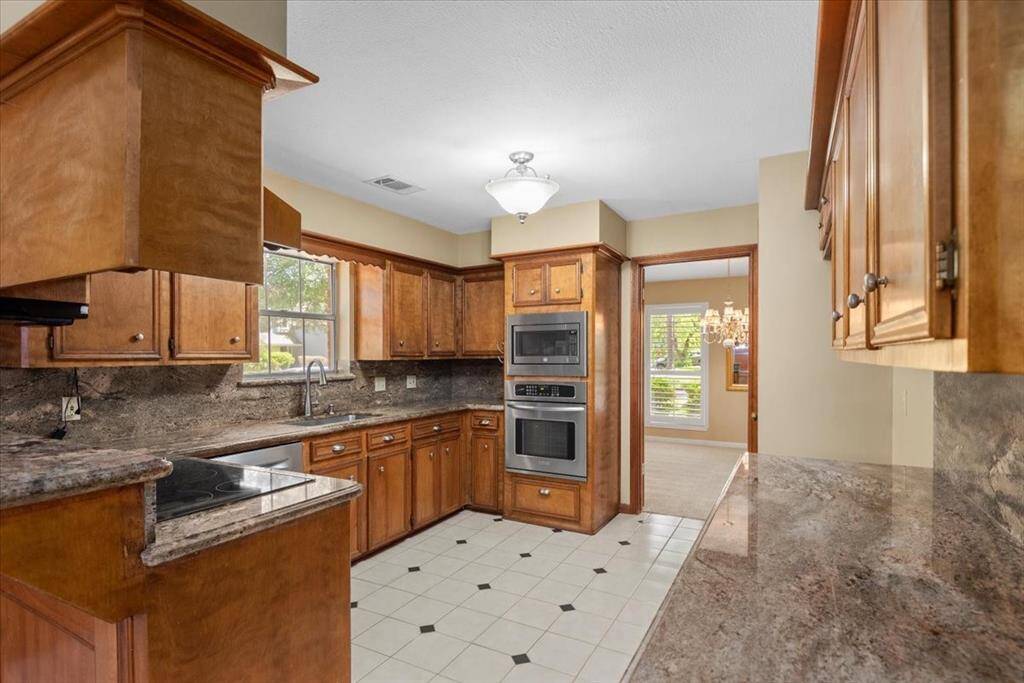 Gourmet kitchen features granite counters, stainless steel appliances and a glass cooktop.