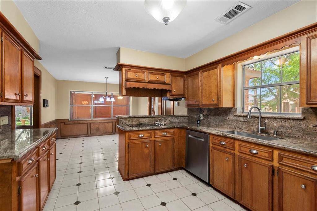 Rich wood stained cabinetry in the kitchen provides plenty of storage.