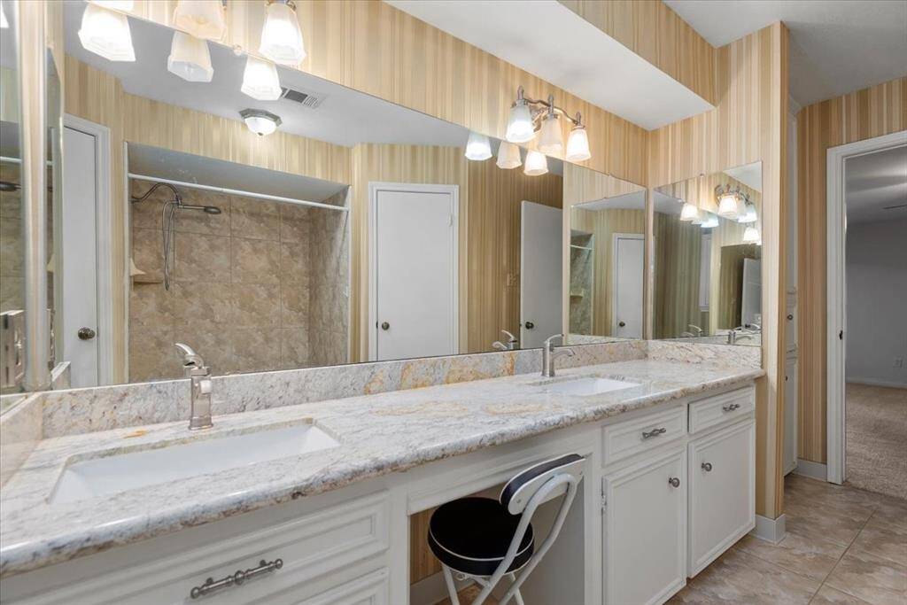 The primary bathroom includes a vanity area and built-ins for toiletries and linens.