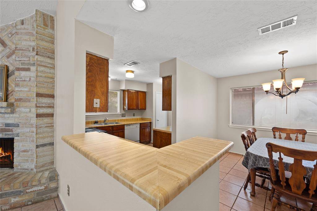 The kitchen offers plenty of cabinet and countertop space. It is connected to the breakfast/dining area and partially open to the living room.
