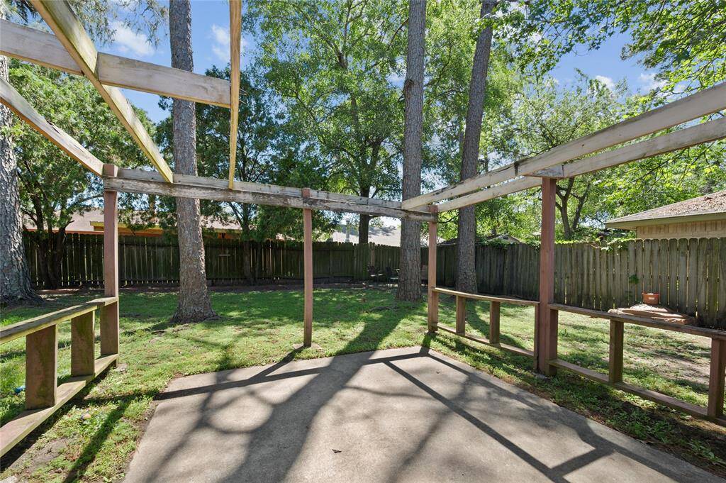 The backyard features a large concrete patio and mature trees!