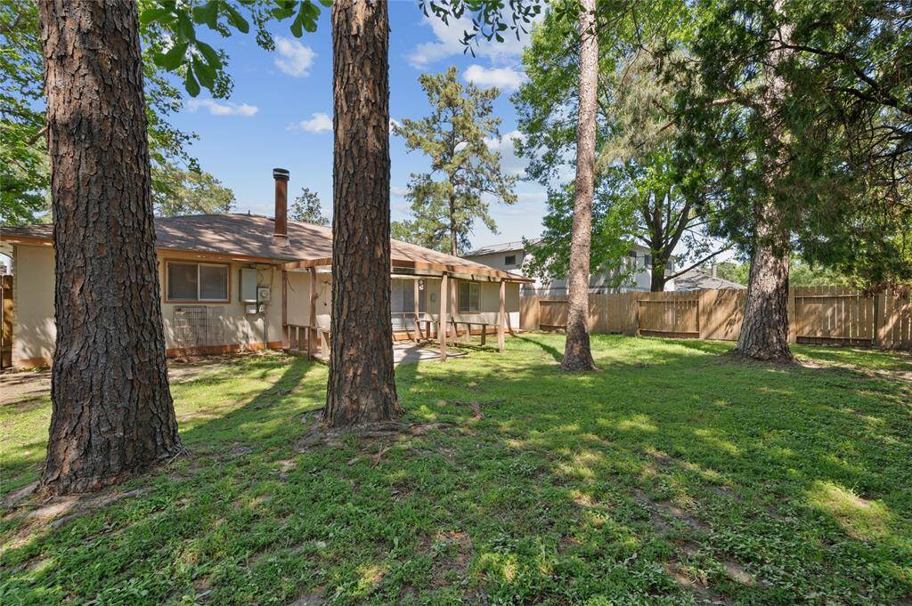 The backyard features a large concrete patio and mature trees!
