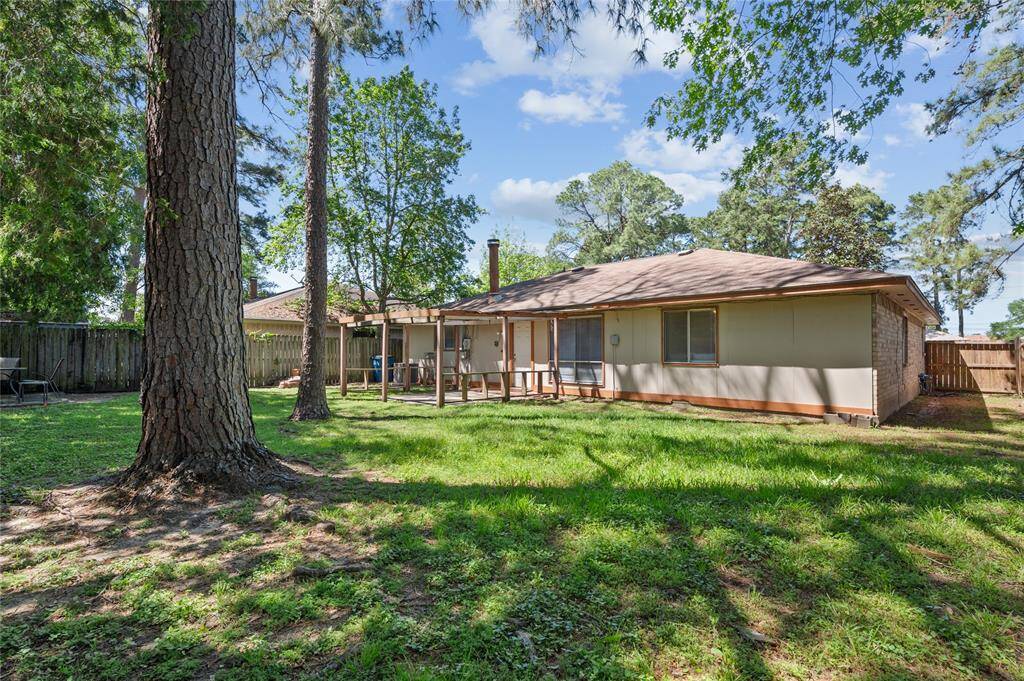 The backyard features a large concrete patio and mature trees!