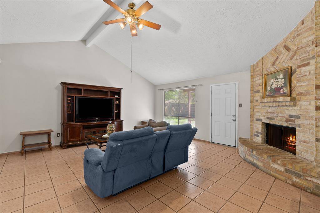 The living room features easy-to-maintain tile floors, a large living room, and a beautiful brick fireplace.