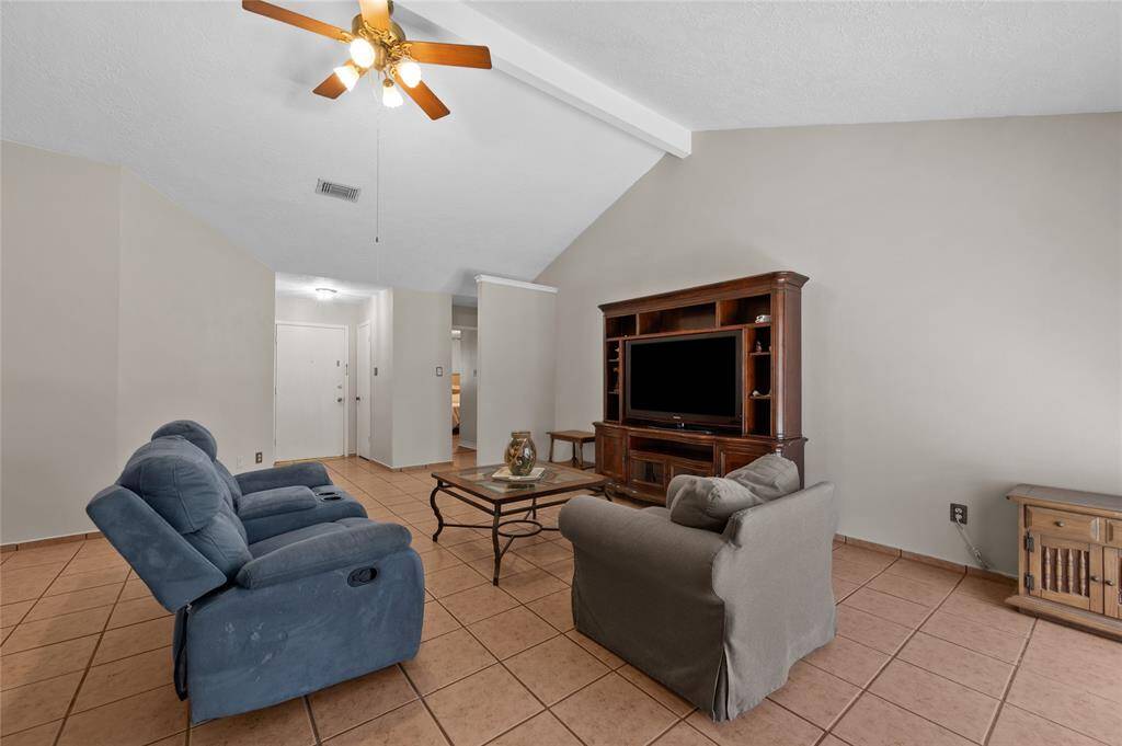 The living room features easy-to-maintain tile floors, a large living room, and a beautiful brick fireplace.