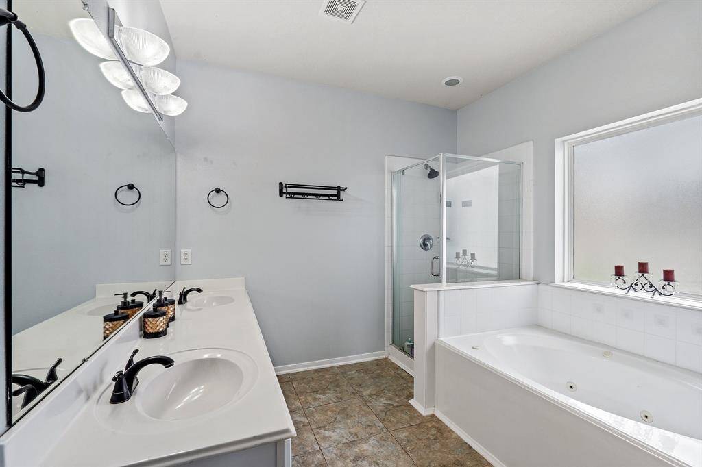 The primary bathroom features a spacious layout with a jetted tub, separate shower, and a water closet for added privacy—comfort meets function.