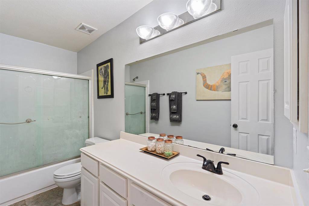 The upstairs full bathroom serves the secondary bedrooms and game room, featuring a clean, functional layout with ample counter space and storage.