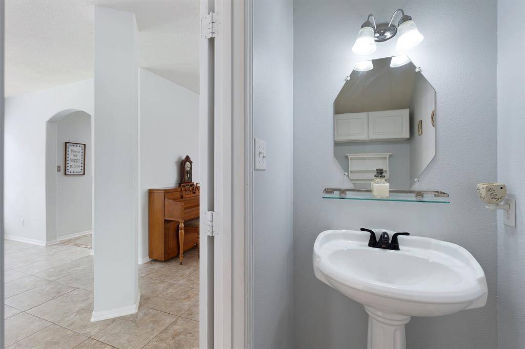 Tucked beneath the stairs, the powder room offers added privacy—conveniently located yet thoughtfully separated from the kitchen and main living areas.