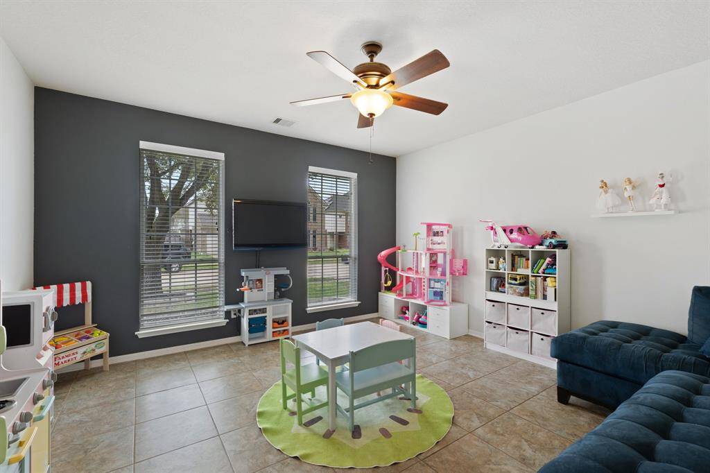 Just off the entryway and tucked beside the stairs, this versatile den welcomes you with natural light and flexible potential—perfect as a home office, playroom, or even a future bedroom.