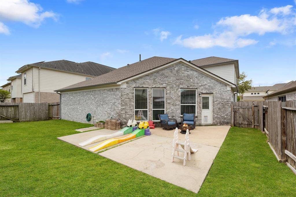 From the back fence, you’ll see this great backyard that’s ideal for entertaining—plenty of space for seating around a fire pit, an outdoor kitchen, a dining table with chairs and an umbrella, a hammock, or anything else you can imagine!