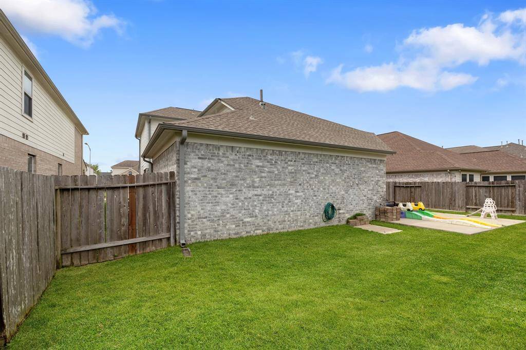 This view highlights the generous size of the yard, offering plenty of green space for play, pets, or future landscaping ideas.